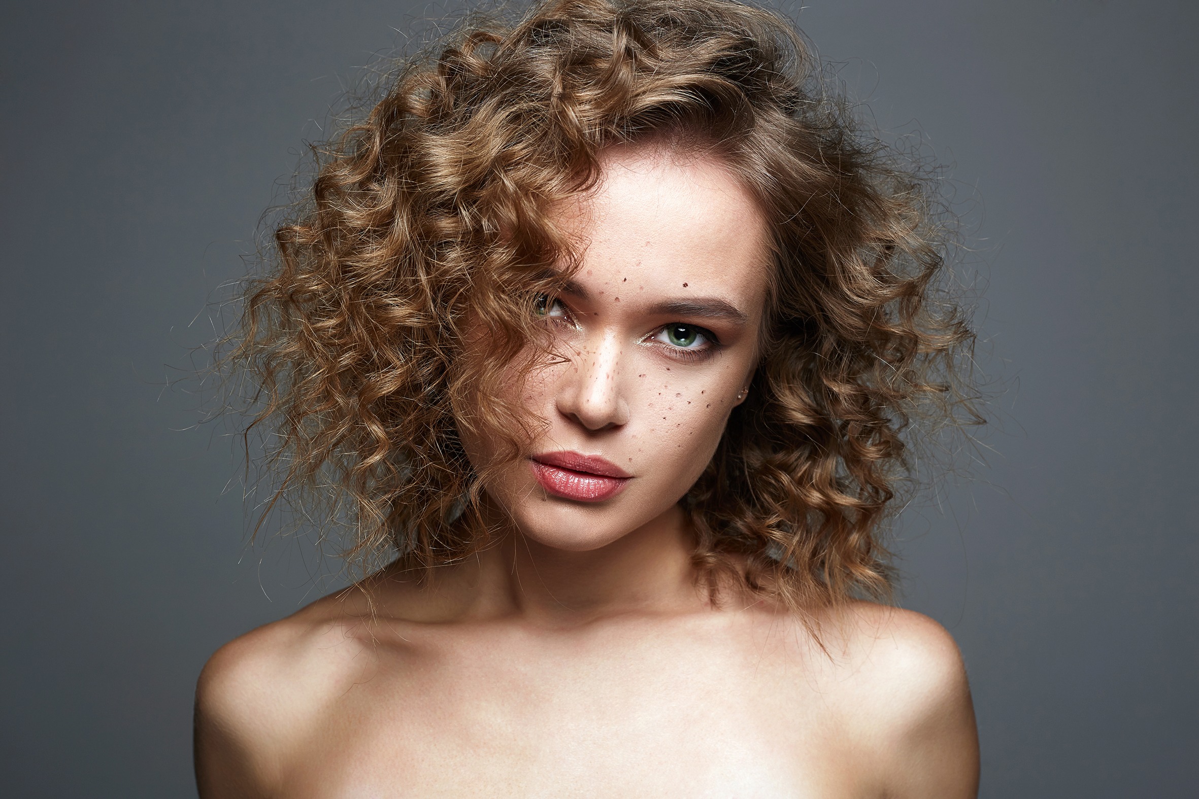 Beautiful freckles woman face. amazing curly girl with make-up. beauty fashion portrait. frizzle hair