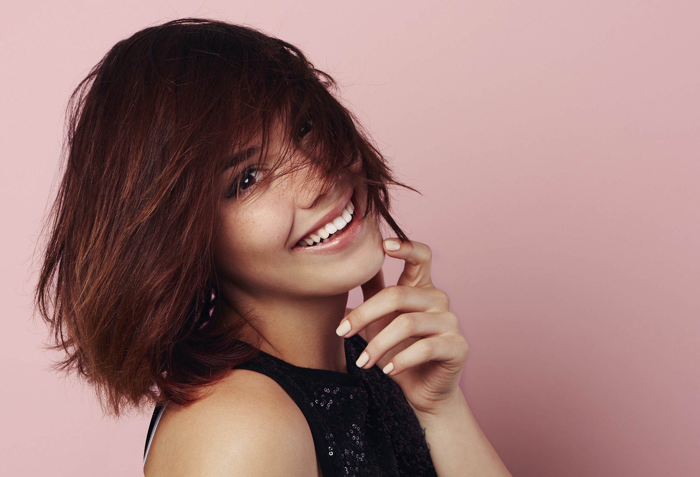 Beauty portrait of smiling female model with windy hair over pin